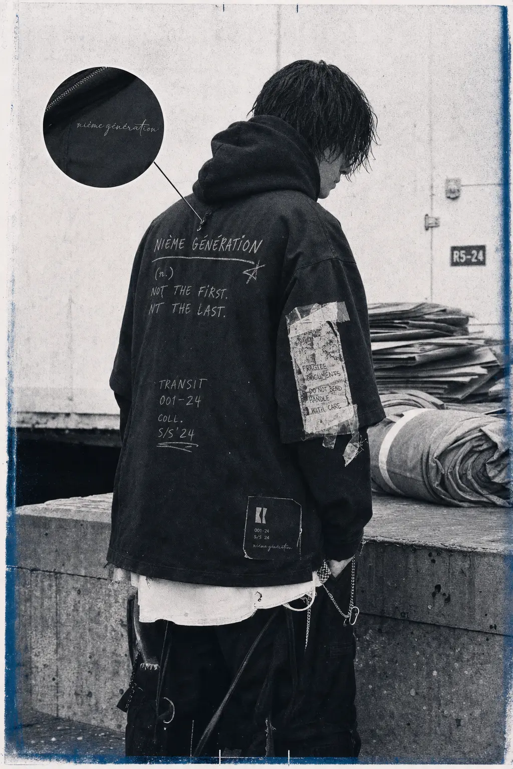 Campaign photograph: figure in an oversized hand-lettered nième génération jacket on a loading dock